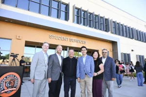 A group of six people posing in front of the Student Services building at Orange High School.